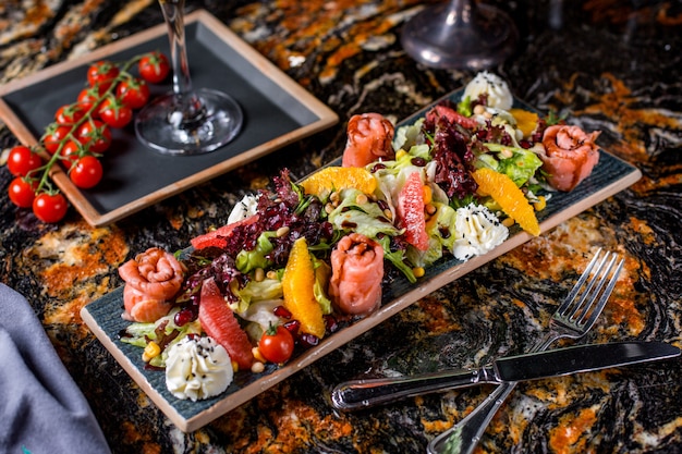 Insalata di salmone con lattuga, pomodori, mais, arancia, pompelmo, melograno e panna 1