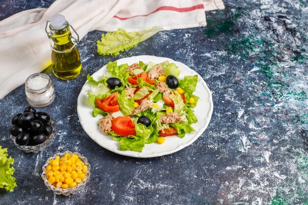 Insalata di tonno con lattuga, olive, mais, pomodori, vista dall'alto