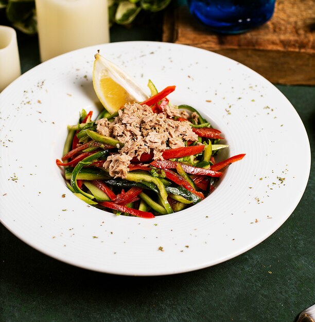 Insalata di verdure con cetriolo, peperone, pollo tritato e limone in olio d&#39;oliva.