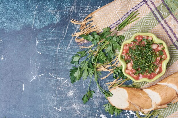 Insalata di verdure con erbe e spezie servita con baguette.