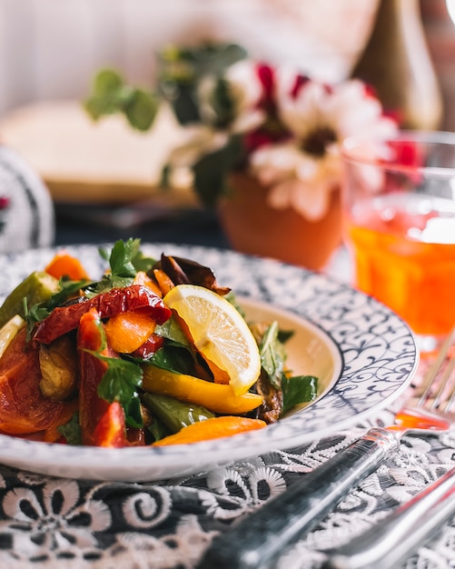 Insalata di verdure con pomodoro, peperoni saltati, prezzemolo, limone e olio d'oliva