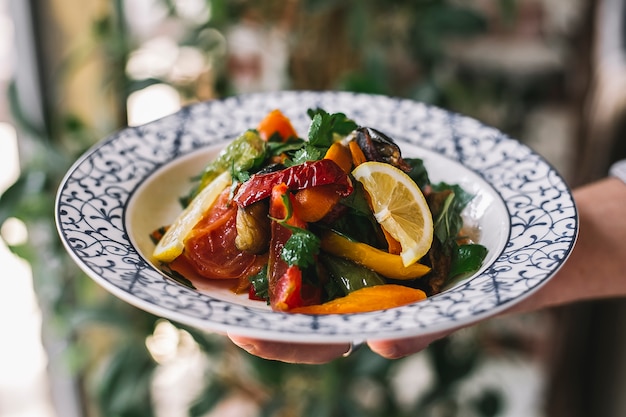 Insalata di verdure con pomodoro, peperoni saltati, prezzemolo, limone e olio d'oliva