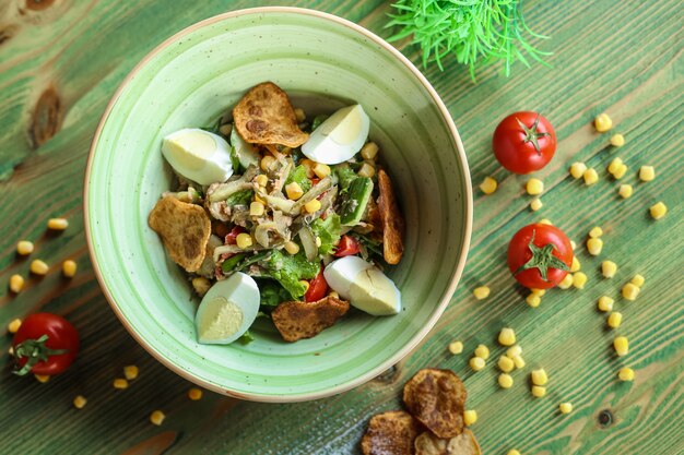 Insalata di verdure con uova affettate e patatine vista dall'alto