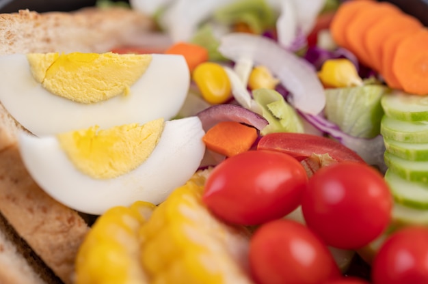 Insalata di verdure con uova sode in un piatto bianco.