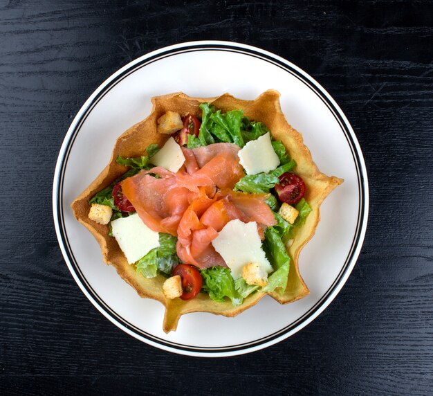 Insalata di verdure condita con salmone affumicato e formaggio