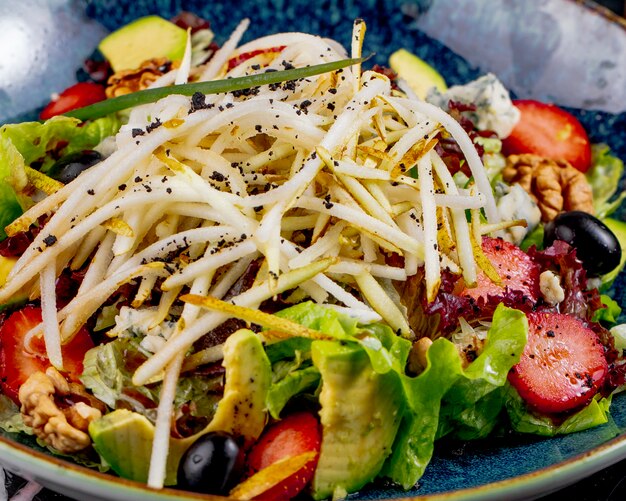 Insalata di verdure di vista frontale con le fragole e l'uva di frutta in un piatto