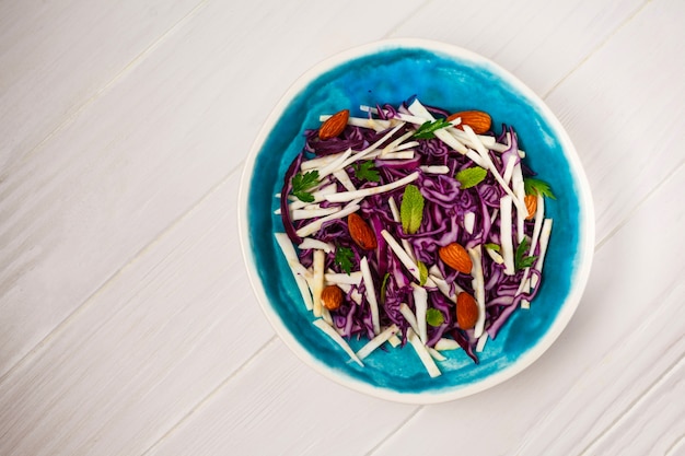 Insalata di verdure e verdure fresche su superficie di legno bianco