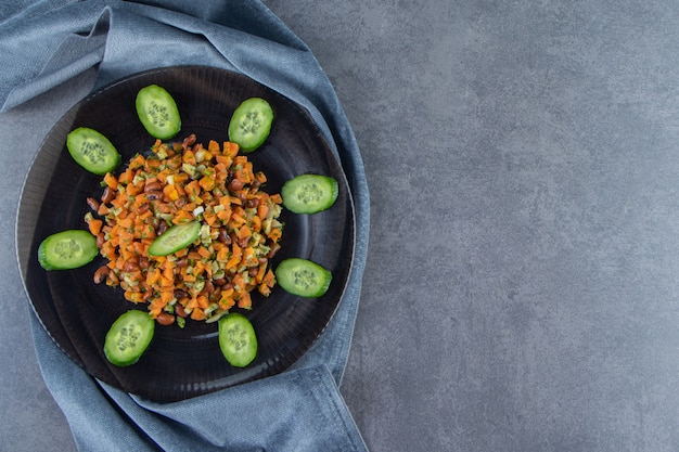 Insalata di verdure su un piatto su un asciugamano sulla superficie di marmo