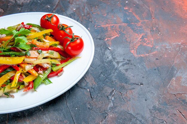 Insalata di verdure vista metà inferiore su piatto ovale su spazio copia superficie scura