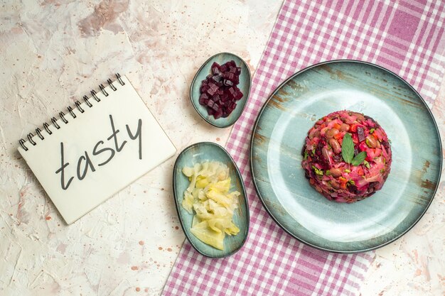 Insalata di vinaigrette a metà vista dall'alto su piatto ovale. gustoso scritto sul taccuino