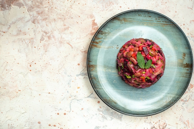 Insalata di vinaigrette vista dall'alto su piatto ovale su tavolo grigio chiaro con posto copia