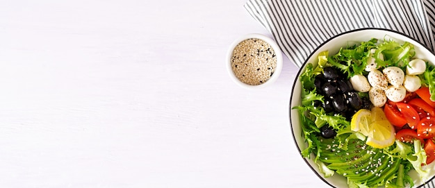 Insalata fresca con avocado, pomodoro, olive e mozzarella in una ciotola