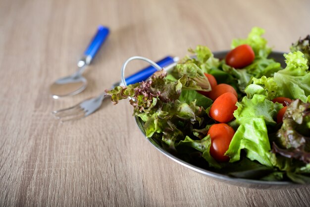 Insalata fresca con verdure e verdure sul tavolo di legno. Concetto di cibo sano.