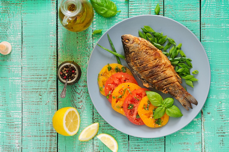 Foto gratuito insalata fritta della carpa e della verdura fresca del pesce sulla tavola di legno. disteso. vista dall'alto