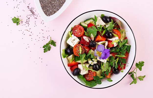 Insalata greca con cetrioli, pomodori, peperoni, lattuga, cipolla verde, formaggio feta e olive con olio d'oliva. Cibo salutare. Vista dall'alto