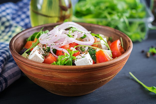 Insalata greca con pomodoro fresco, cetriolo, cipolla rossa, basilico, formaggio feta, olive nere ed erbe italiane