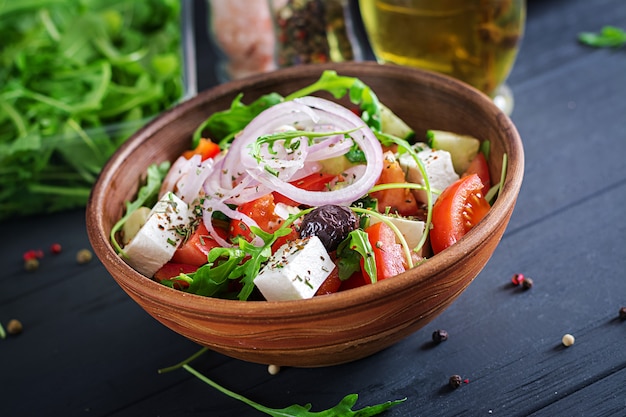 Insalata greca con pomodoro fresco, cetriolo, cipolla rossa, basilico, formaggio feta, olive nere ed erbe italiane