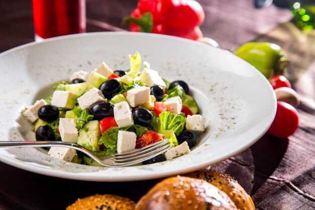 Insalata greca di vista laterale con pane alle olive nere e funghi