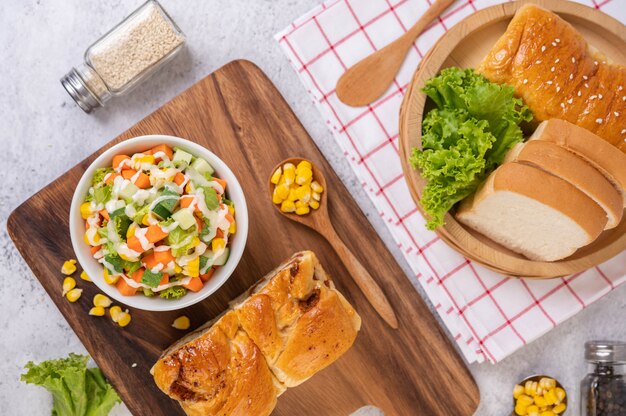 Insalata, mais, carota e lattuga di cetriolo in una tazza bianca.