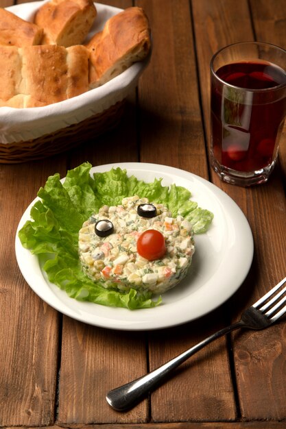 Insalata maiuscola con occhi di oliva e naso di pomodoro