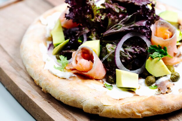 Insalata mista con fette di pesce servita su pane