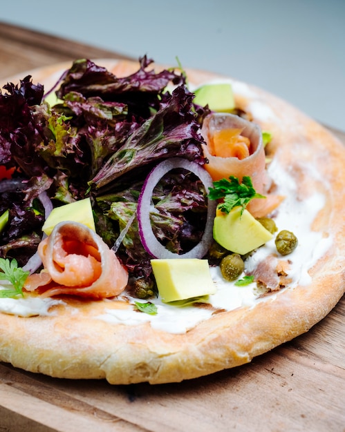 Insalata mista con fette di pesce servita su pane