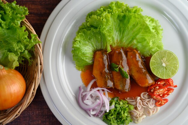 Insalata piccante di sardina con salsa di pomodoro in piatto bianco