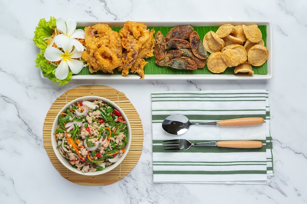 Insalata piccante mista con salsiccia vietnamita, uova conservate e calamari croccanti, cibo tailandese.