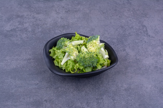 Insalata verde con erbe e spezie in un piatto di ceramica