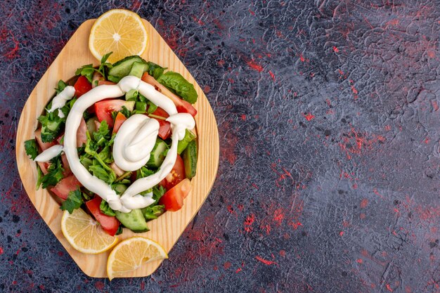 Insalata verde in un piatto di legno con salsa di maionese.