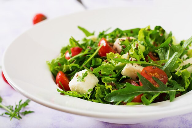 Insalata vitaminica di pomodori freschi, erbe aromatiche, formaggio feta e semi di lino. Menu dietetico. Nutrizione appropriata.