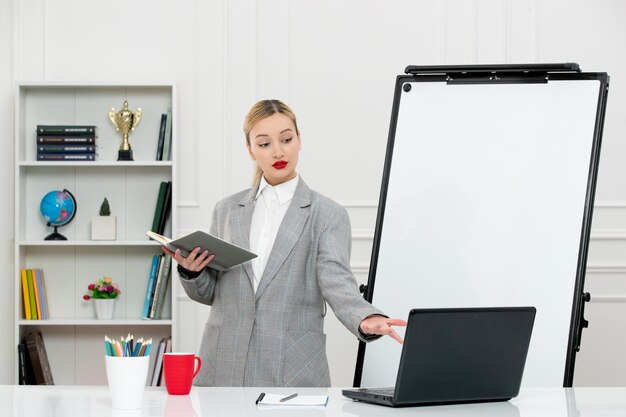 Insegnante carino istruttore in tuta in classe con computer e lavagna guardando lo schermo