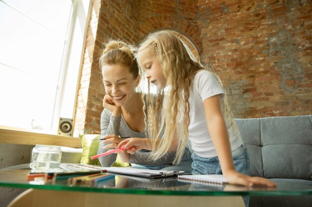 Insegnante caucasico femminile e bambina, o mamma e figlia. Istruzione domiciliare