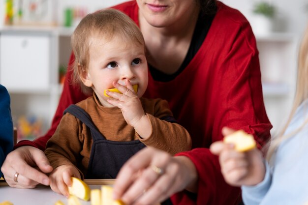 Insegnante di smiley che tiene bambino che mangia