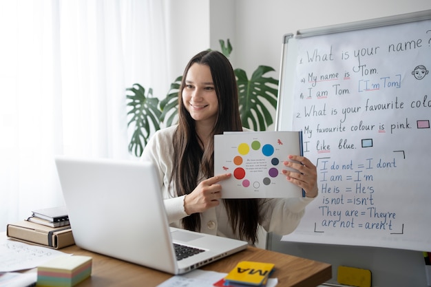 Insegnante di smiley di tiro medio con il computer portatile