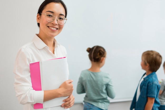 Insegnante di smiley in posa accanto agli studenti