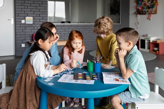 Insegnante di tiro medio che aiuta i bambini a imparare