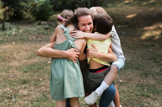 Insegnante di tiro medio e bambini che si abbracciano