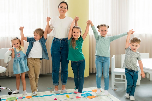 Insegnante di vista frontale e bambini che propongono insieme