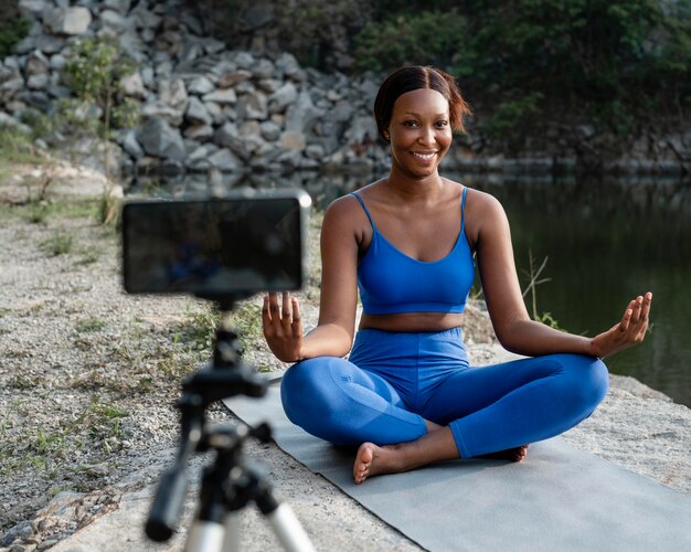 Insegnante di yoga afroamericano che pratica all'aperto