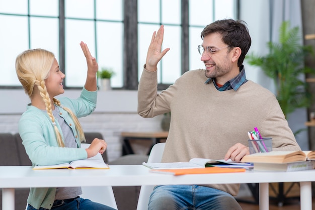 Insegnante e giovane studente alto cinque