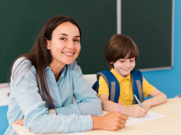 Insegnante e studente seduto in classe