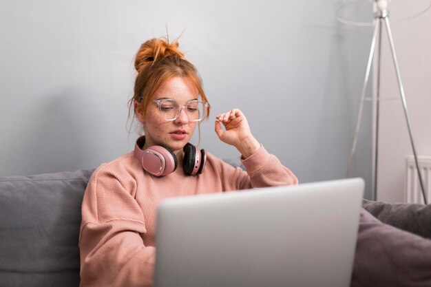 Insegnante femminile che utilizza laptop da casa per tenere una lezione online