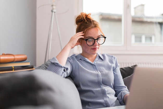 Insegnante femminile sullo strato a casa che tiene una classe in linea