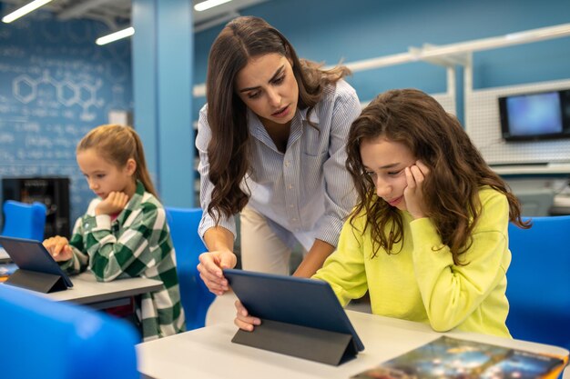 Insegnante si chinò pensando ragazza con tablet