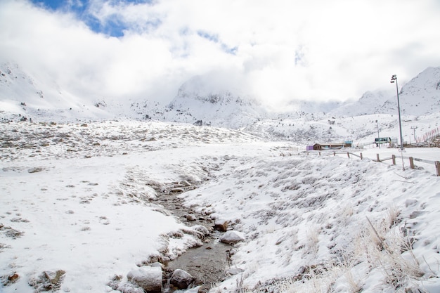 Insenature circondate da alte montagne coperte di neve sotto il cielo nuvoloso