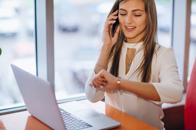 Intelligente donna parla al telefono e guardando al momento