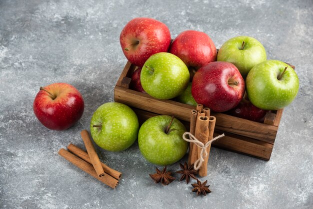 Intere deliziose mele verdi e rosse in scatola di legno.