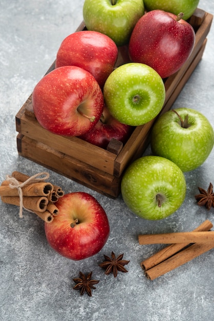 Intere deliziose mele verdi e rosse in scatola di legno.