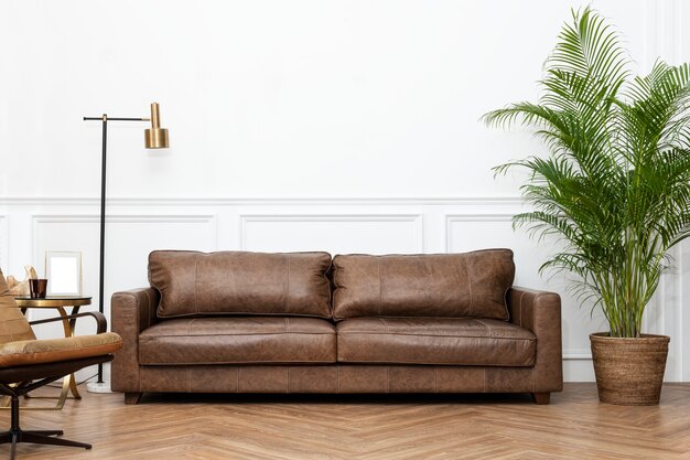 Interno del soggiorno in stile industriale moderno di lusso con divano in pelle, lampada dorata e piante d'appartamento